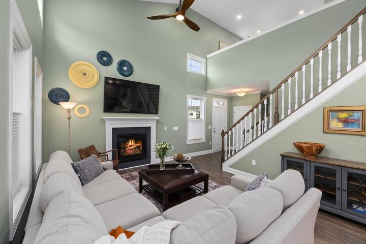 Living room with a framed fireplace, staircase and seating